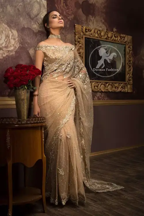 Banarsi jamawar blouse contains embroidered border on the neckline. Net saree contains flourishing embellishments all around the edges. Stones spray