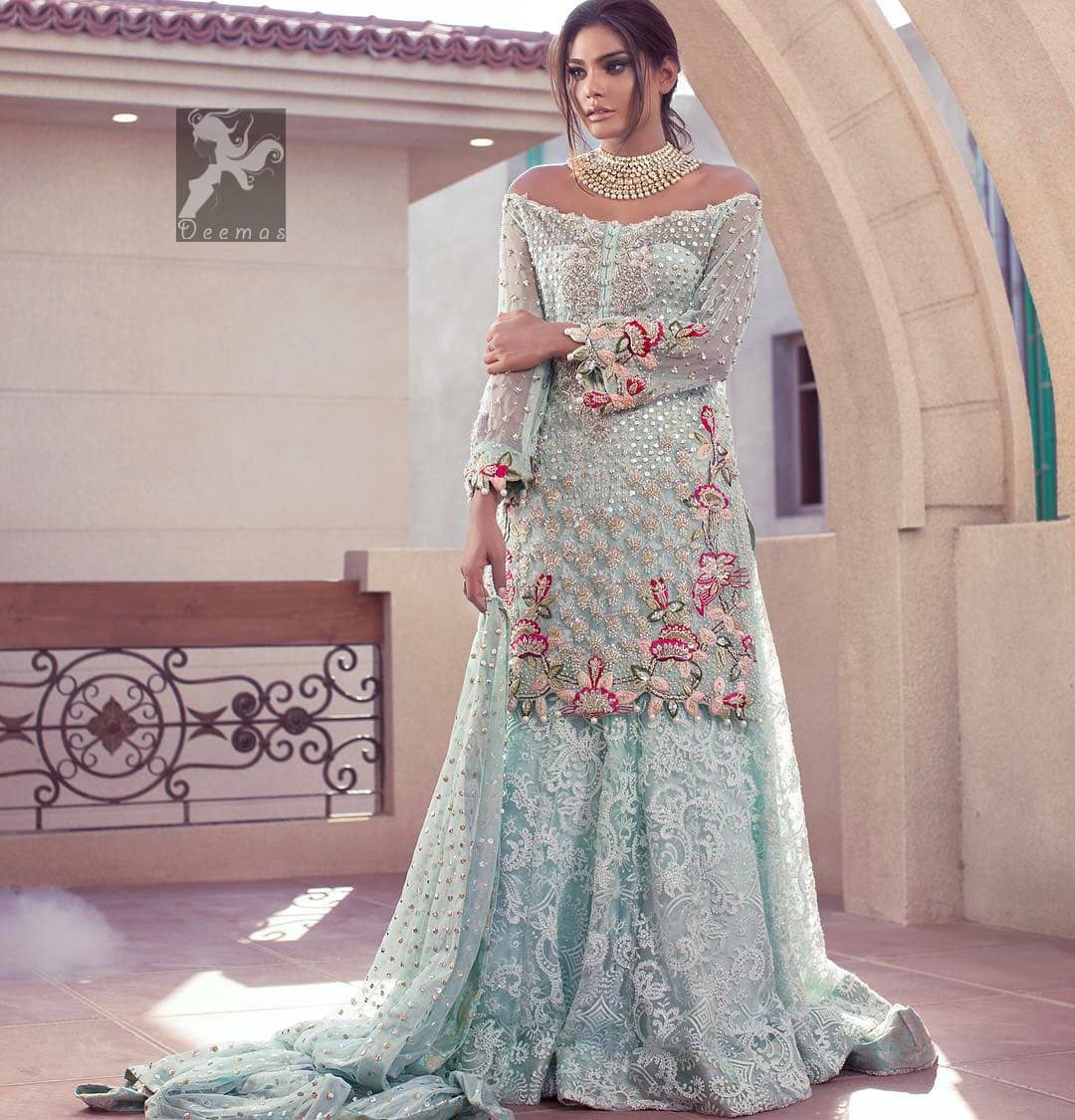 Sweetheart neckline pure crinkle chiffon shirt adorned with embellishment. Embellishment includes majorly light golden, silver, shocking pink and mehndi green shades. Shirt comes with embroidered sharara and net dupatta.