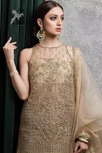 Light golden brown pure organza short shirt having halterneck design. Shirt has been embellished with antique and different shades of embellishment. Small embellishment border on dupatta. Sharara is adorned with embellishment all over it.