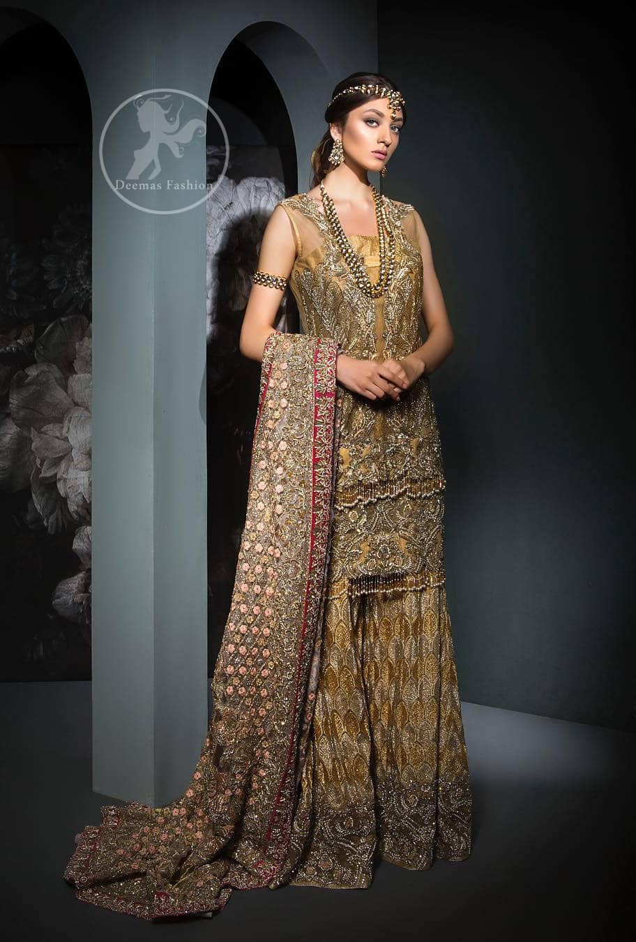 This dress is beautifully sculptured with floral embroidery. It is meticulously highlighted with antique shaded kora, dabka, tilla, sequins and pearls. It is allured with beautiful tassels which adds to the look. It is beautifully paired up with embroidered brocade sharara. It comes with organza/tissue dupatta which has four sided embellished border and applique.