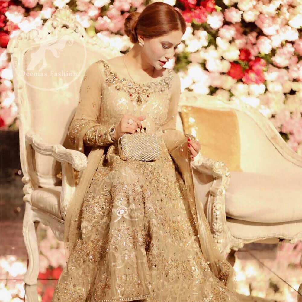 Delicately crafted and personifying chic elegance with an element of grandiose. This pretty gold embroidered frock done with kora dabka, tilla, diamante and sequins. Hemline edges are fully decorated with pearls. It comes with Brocade Pajama and Net dupatta sequins spray all over.