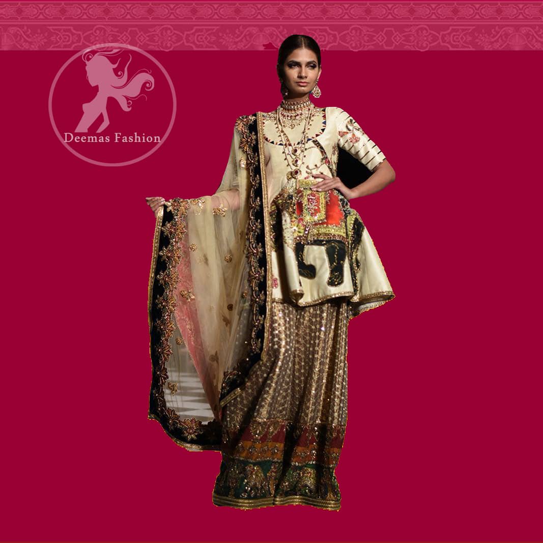 This signature angrakha is crafted with raw silk featuring hand embroidery with elegant zardoze work. The sharara with it is made of brocade with applique detail on bottom done with kora dabka, kundan and tilla work. It comes with ivory dupatta adorned with black applique and heavy embellished borders on all sides.
