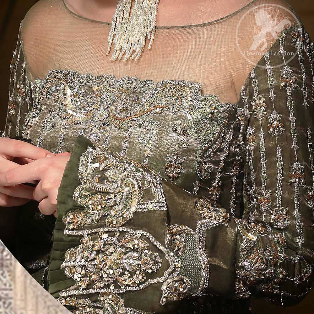 The beautiful bodice is decorated with intricate stones and sequins. It is further enhanced with vertical lines and floral motifs done with kora dabka, tilla, sequins and colorful thread work. Paired up with embroidered bell bottom. This outfit is beautifully coordinated with olive green dupatta with embellished borders on sides and sprinkled sequins.