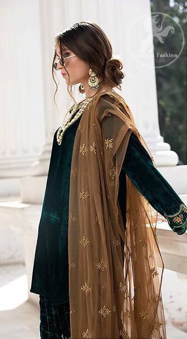 Take a step towards refreshing your wardrobe with bottle green velvet Shirt. The shirt is perfected with delicate gold tilla work. Add this bottle green velvet golden embellished bell bottom for a complete look. It comes with golden net dupatta enhanced with small motifs on the ground.