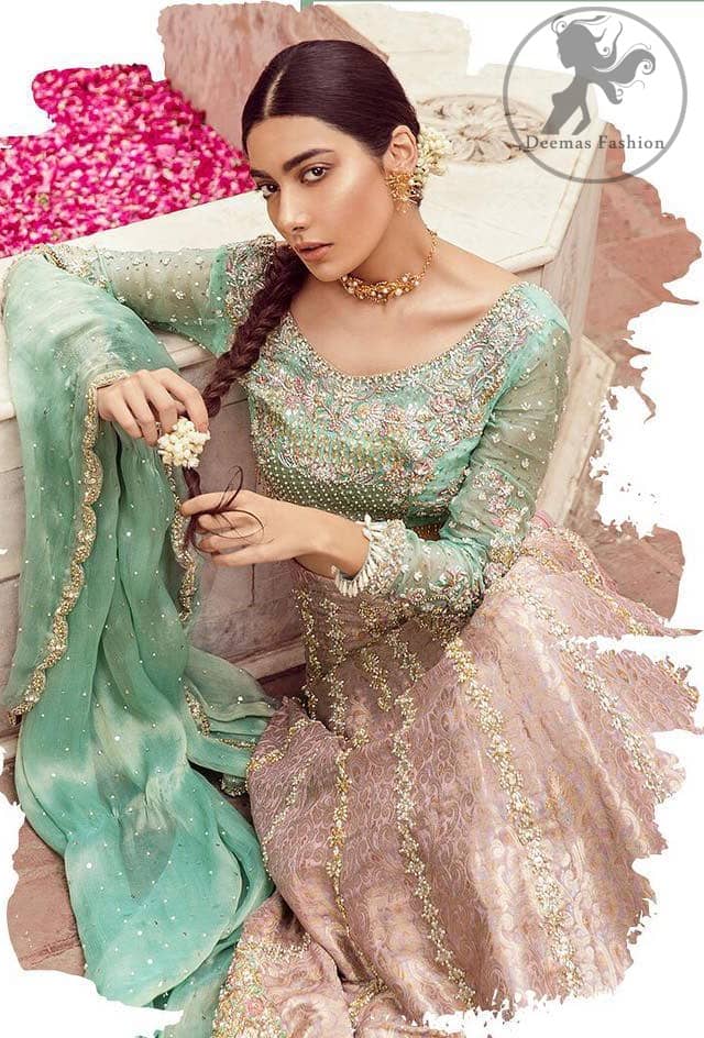 The bridal stands out due to its uniqueness and the perfect fusion of modern cut and traditional embroidery. This dress is beautifully decorated with heavy embroidery. It is highlighted with dull golden kora, dabka, tilla, sequins, pearls and thread embroidery. This outfit comes with salmon pink lehenga which is enhanced with embroidery on bottom. It is coordinated with tissue dupatta which is sprinkled with sequins all over it. It is further furnished with four sided scalloped border.
