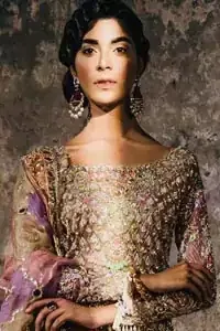 This bridal dress stands out due to its uniqueness and the perfect fusion of modern cut and traditional embroidery. It is enhanced with kora, dabka, tilla, gota, sequins and pearls. Shirt is fully embellished in crisscross pattern. It is artistically coordinated with tissue gharara which is adorned with colourful motifs and colourful embroidered dupatta detailed with gold gota work and finishing adds to the look.
