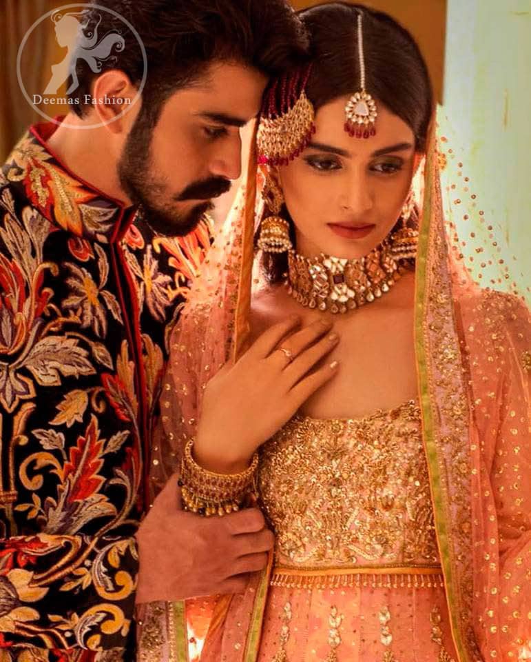 A handful of stardust on a contemporary dress, crafted delicately with dainty floral embroidery and gotta work embroidery. It is beautifully captivated with golden kora dabka, pearl and kundan work. It is finished with heavy embroidered and lace on border. Paired up with churidar pajama and net dupatta with sprinkled sequins and piping on all sides.