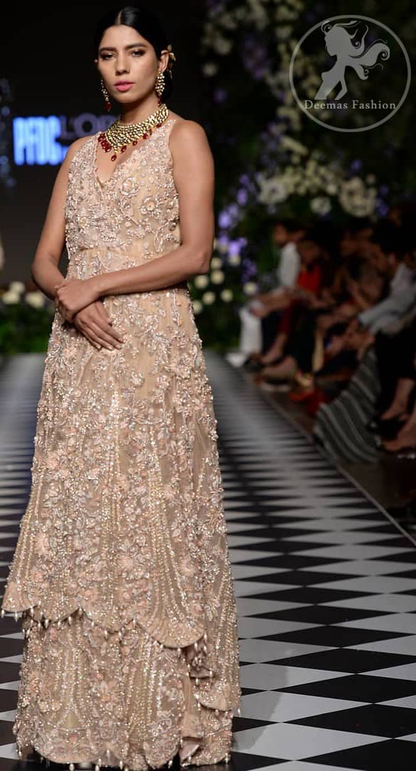 Brighten up your look with this outfit. This dress is beautifully sculptured with floral embroidery, adorned with cutwork borders embellished with dull golden kora, dabka, pearl and sequins work all over. Sharara comprises of floral thread embroidery and zardosi work adorned with thick embellished border. It is coordinated with tissue dupatta which is sprinkled with sequins all over it. It is further furnished with four sided scalloped border.