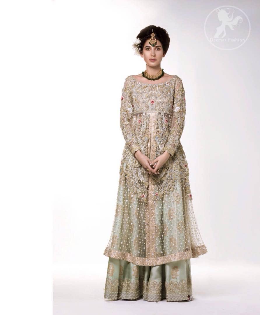 The perfect combination of tradition and class. Dazzle in this made to perfection, richly embroidered front open net outfit decorated with intricate zardozi embroidered front highlighted with kora, dabka, tilla, sequins and pearls embroidered borders on daaman and sleeves. Furthermore the shirt is fully decorated with sprinkled pearls all over it. This outfit is comprises with light olive green sharara highlighted with zardozi details at the bottom. Complete the look with tea rose dupatta sprinkled with sequins all over.