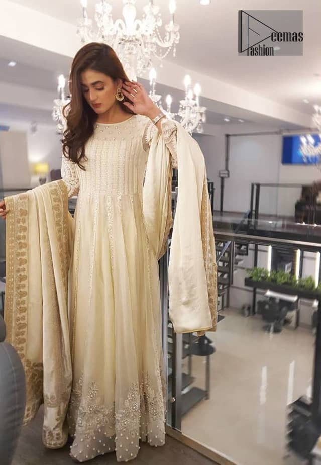 This outfit is perfect for nikah day. Exude elegance and class in this anarkali frock finessed with beautiful embellished bodice with matching thread embroidery and pearls. This trendy outfit is enhanced with thick borders and floral bunches refined the classical royal look. Having full length sleeves adorned with floral motifs. It comprises with churidar pajama. The dupatta incorporates beautifully designed borders on all four sides, focusing on the heavily embellished pallu borders to give it a perfect look.