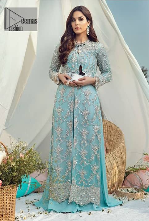 The perfect combination of tradition and class for your walima. This heavenly handcrafted front open style bridal showcases the traditional art of zardozi, nakshi, kora, dabka, sequins and beads, adorning the intricate and meticulous hand embellishments giving it a wholesome gentle stance paired with sharara. The bottom of the shirt is enhanced with thick scalloped border and finishing with tassels. Having full length sleeves adorned with sequins and and embellished floral bootis. The outfit is beautifully coordinated with matching dupatta with scalloped borders on all sides and sequins spray all over.