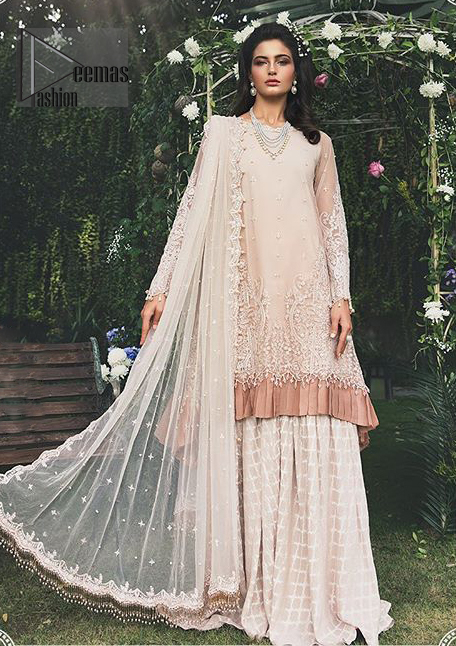Go for this trendy dress which is perfect for your nikah. Feel glamorous in our ivory a-line frock with fascinating embellishment on neckline with silver kora, dabka, pearl and sequins. The daman is emphasized with detailed matching embellishment and finished with choclate brown frill. It comprises with sharara adorned with criss cross pattern. This outfit is paired up with net dupatta focusing on kora and dabka handwork borders on all four sides, sequins spray all over and finished with tassels.