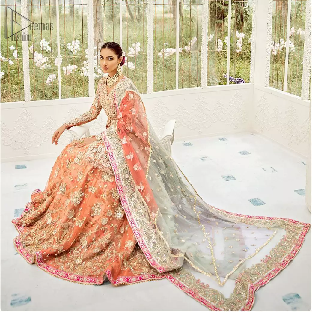 Captured in traditional silhouette, The bridal stands out due to its uniqueness and the perfect fusion of modern cut and traditional embroidery. This front open short frock is highlighted with kora, dabka, tilla, sequins and pearls. It comes with full embellished lehenga adorned with floral bunches, applique on the hemline and sequins spray all over it. It is coordinated with organza dupatta which is sprinkled with tiny floral motifs all over and a thick embellished border on all four sides with applique details.