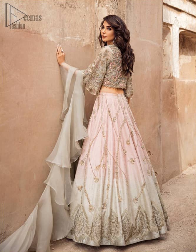 This artisanal piece is rendered in grace and timelessness. An example of beauty and elegance. Look breathtakingly stylish in this embroidered regalia furnished with intricate embroidered blouse and scalp third quarter bell sleeves. It comprises with gradient lehenga having light pink and mint green colors done with zardozi floral bootis and a thick embellished bottom. Style it up with mint green organza dupatta.