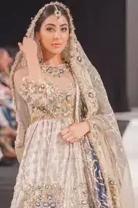This artisan piece includes intricate hand-embellishment. This technique gives your garments a unique look, and helps to sustain a traditional craft carried out by skilled artisans across Asia. Adorned with dull golden zardozi and multiple color thread embroidery around the neckline and bodice. Furthermore the scalloped bottom is ornamented with floral jhaal, multiple color embellished floral bootis and tiny motif all over. Style it up with gray dupatta done with gotta work and cigarette pants.