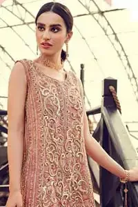 Delicately crafted and personifying chic elegance with an element of grandiose. You are all set to make a lasting impact with the divine royalty of this dress. The outfit is perfected with loaded dull golden, golden and antique work. The shirt is delicately hand crafted using the finest old age techniques and materials including kora, dabka, tilla, sequins and pearls. The back of the shirt is highlighted with cutwork embellishment. Furthermore it is also enhanced with thread embroidery. This outfit is comprises with peach raw silk bell bottom. Complete the look with peach organza dupatta decorated with sequins spray all over.