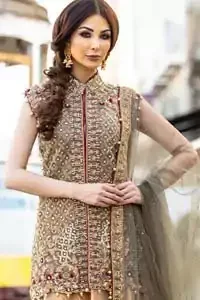 Our selection of wedding dresses offers simple evening glamour dresses. Add a taupe gray color to your wardrobe with our modern styled front open shirt enhanced with embellished geometric patterns. The neckline is beautifully designed with collar neck and scalloped hemline is emphasized with dangling pearls and multiple color embroidery. It is paired with taupe gray dupatta with one sided hand embellished border and sprinkled sequins all over. Compliment the look with fawn lehenga adorned with floral bunches. The combination of fawn and taupe gray is absolutely breathetaking.