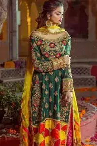 Beautifully elegant with a modern twist. This beautiful outfit comes with bottle green long shirt and colorful applique hemline, making an elegant, traditional and stylish mehndi dress. Excellence of craftsmanship is evident with intricate geometrical detailing that features the use of kora, dabka, crystals, sequins and glass beading. Furthermore it is enhanced with colorful floral motifs and golden zardozi work. It comprises with pink capri pants. Elegance is personified when it gets paired up with net dupatta with kiran on all sides and colorful strips on pallu.
