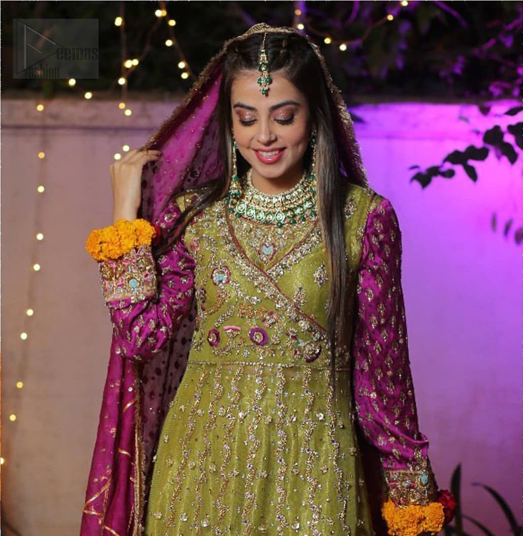 Nothing speaks of femininity and class louder than this mehndi outfits for bridesmaids. The sequinned whimsical florals embroidered across the flattering bodice in this ethereal frock is sure to turn heads in every room you walk into. The pairing of champagne zardozi work with parrot green fabric is an artist’s dream colour palette. The frock hemline is emphasized with banarsi applique details that gives perfect ending to this outfit. It comprises with matching tissue lehenga. The magenta organza dupatta with chann and gota work, finishing with kiran lace all around the edges makes the look complete. 