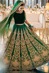 This artisanal piece is rendered in grace and timelessness. This outfit makes a statement in this stunningly floraison, perfect blend of glamour and tradition with outstanding craftsmanship and gorgeous detailing. This mehndi dress in a dreamy shade of green, enhanced with hand embellishments on neckline and sleeves. The wide flared lehenga is an example of remarkable handiwork with a lot of attention to detail. The sculptured embroidery is in the shade of golden. Complete the look with bottle green organza dupatta emphasized with tiny floral motifs on the ground and four sided embellished border.
