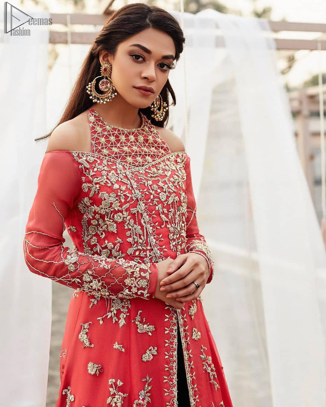 This outfit brings drama and playfulness to traditional frock and Sharara with a modern approach. Drape yourself to perfection for the classic affair in this flattering front open ensemble festooned with intricate zardozi hand embroidery work and motifs. The frock is furthermore adorned with halter neckline and comprises with overlaped bodice. Embellishment is done with zardozi embroidery in silver color. This outfit is comprises with bottle green velvet sharara and coral chiffon dupatta with sequins spray all over.