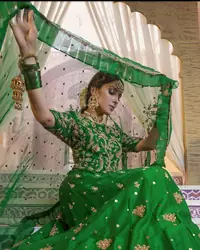 Nothing speaks of femininity and class louder than this green mehndi outfits for bridesmaids. This beautiful outfit comes with a green lehenga which is beautifully embellished with motifs, sprinkled with sequins and it finished with a thick embellished border. The blouse is breathtakingly ornamented with floral bootis which covers every inch of the blouse. The dupatta incorporates beautifully designed scalloped borders and frilled on all four sides. The kora, dabka, tilla, sequins and pearls work are done in the shades of golden.