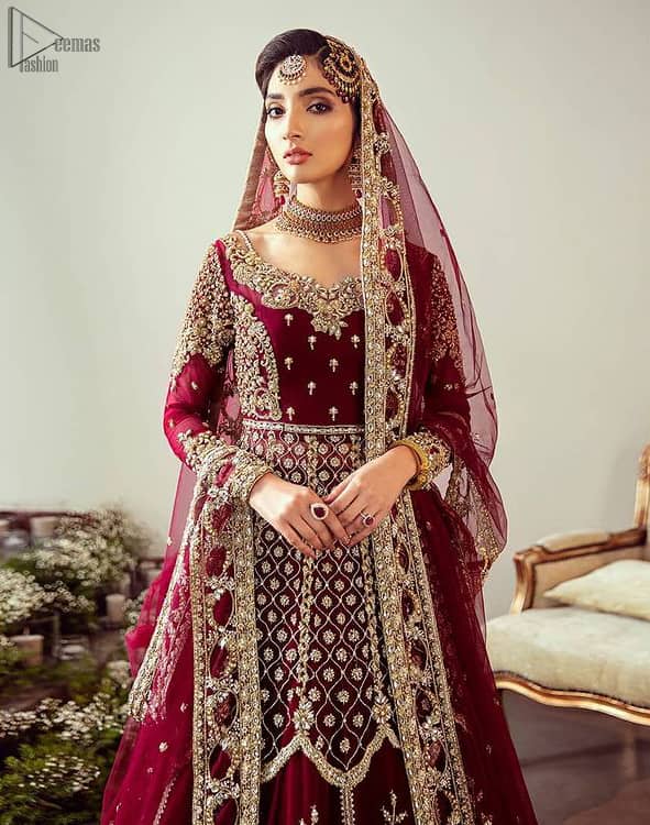 Maroon Floor Length Pakistani Reception Wear Pishwas with Bridal Dupatta and Churidar Pajama. A sensational affair so timeless and magnificent, beautifully crafted with light golden zardozi work. Craftmanship and skills you've never witnessed before. It is paired with an ethereal bridal dupatta focusing on kora and dabka handwork borders on all four sides, finishing with scattered tiny floral motifs on the ground.