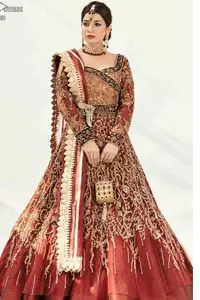 Dress up traditionally with Deemas Fashion's marvellous Burgundy Ball Gown. An exquisite full-sleeved gown followed by a marvellous churidar Pajama. This Maroon gown is made to perfection with splendid golden embroidery, beneath its beautiful sweetheart neckline. A net Dupatta completes the overall dress code and makes you ready for your Reception day. This dress has all the attractions required to have the public's attention on your big day. Pakistani Reception Wear Burgundy Ball Gown - Lehengha.