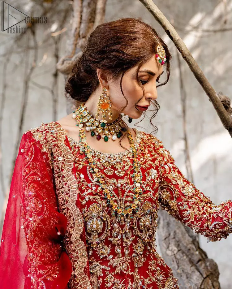 Red Bridal Peplum n Dupatta – Orange Lehenga. Red peplum with pure organza and fully engraved multi colour embroidery is such an eye-catching masterpiece that you would like to wear on your big day. Silver and golden combination of embellishment along with red pearls, Tilla Dabka, Appliques, Sequins and Zardozi work mainly gives such an eye feasting outfit to wear. The rounded, neckline and full sleeves give it a proper finishing in a beautiful attractive peplum style with Kattan Banarsi Jamawar exquisite Lehenga. With a concealed side zip closure along with floral motifs having finished edges. The Red organza dupatta has four-sided embellished borders.