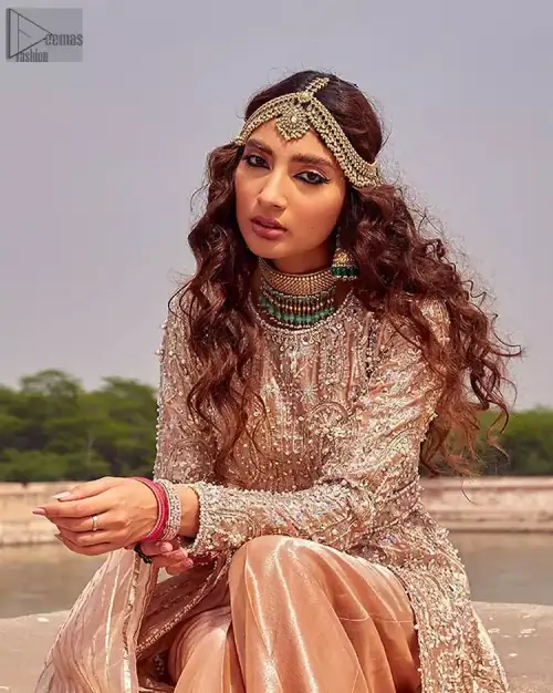 the dress with a tissue dupatta and graceful palazzo pants makes you the center of attention on your big day. Peach