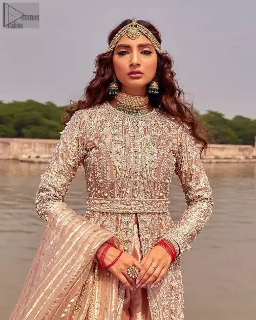 the dress with a tissue dupatta and graceful palazzo pants makes you the center of attention on your big day. Peach