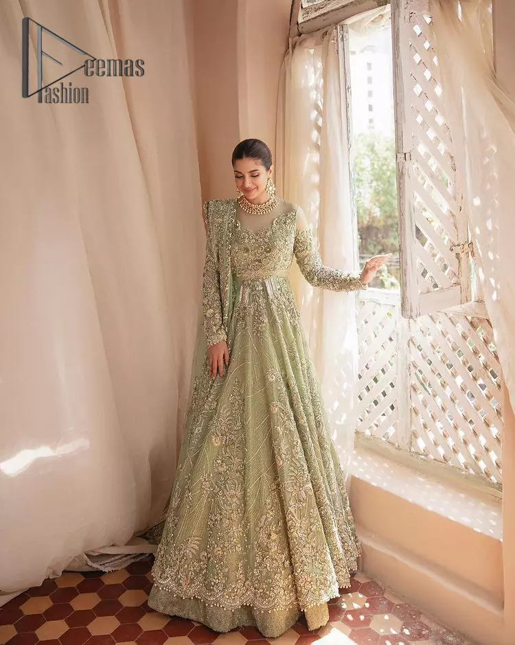 A time of life that is not just an occasion but a celebration. A pastel green scalloped maxi laboriously frosted with meticulously detailed hand embellished with silver tilla, dabka, and kora work blooming all over. Further, the jewel neckline and full sleeves of this article give so soothing feeling to you your walima day. It is handsomely coordinated with a pastel green lehenga that is again beautifully embellished. Complete this article with the organza dupatta in the same colour, heavily laden with a four-sided border and tiny floral motifs all over with a magical stream of pearls. 
