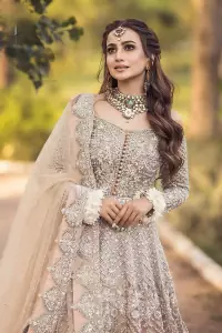 If you believed in mythical stories, shared all your secrets with glorious fairies and want to look like that mythical fairy on your reception then this Beige article is for you. This off-shoulder maxi is beautifully embellished with kora, dabka, tilla, sequins and pearls work, style up with remarkable full sleeves. Introducing this with a ruffled lehenga that looks super stunning and priceless. Followed with a net dupatta that is prominent with hand embellished borders and sequins spray all over that enhances the beauty of the outfit and give you a mythical fairy look as well.