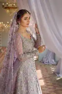 Bold instruments on a bright canvas make a true fashion statement. Introducing a lilac outfit for your Walima day to boost up your day. The front open gown in lilac colour looks as amazing as any bride's dream. It is encapsulated with silver embroidery which contains crystal, tilla, dabka, kora and sequins spray all over. In addition to this, it is highlighted with a sweetheart neckline to enhance the beauty of the gown when combined with full sleeves. It is systemized with silver barcode sharara finished with silver border embroidery that enhances the look of the bride during the day as well as night events. Complete this lilac article with a dupatta which is ornamented with four-sided borders and sequins sprayed all over. 