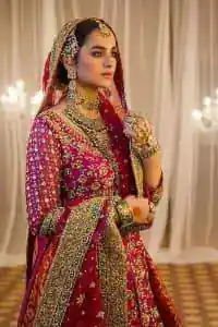 Do you also want to give you a look of the traditional brides on your Mehandi? Make your moment memorable being a queen in our magenta front open shirt with intricately embroidered neckline and embellished with delicate kora, dabka, tilla work all over. A green border of the shirt gives the perfect look to the outfit. It is organized with a red back train jamawar lehenga to give you the look of such a traditional bride. Complete this outfit with a red dupatta which is laboriously adorned with a four-sided border and ting floral motifs all over to give you such a super traditional Mehandi bride vibe.