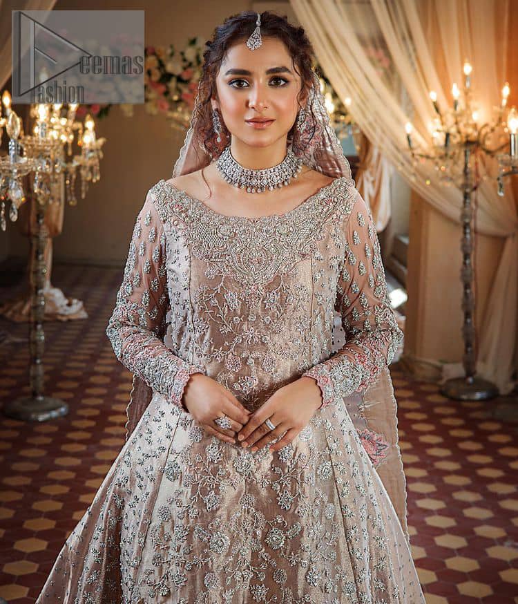 Amplify your style on your Walima day in this stunning light color. DeemasFashion presents the super handsome rose gold outfit for you. First of all, which includes back train maxi in the rose gold colour. It is prominent with the silver embroidery that is encrusted with pearls, silver crystals, kora, dabka and sequins all over highlighting floral patterns. Further, it is emphasized with boat shape neckline and full sleeves that increase the opulent statement of the outfit. It is organized with rose gold sharara which is also embellished with heavy silver embroidery to make your day super dazzling. Finish this look with the rose gold dupatta that is accentuated with sequins and booti spray all over and adorned with a four-sided matha Patti border. 