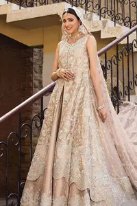The subtle colour palette, delicate embroidery and eye-catching details. All in all a true style statement! Presenting this fawn maxi which is a luxuriously encrusted masterpiece is laden with tilla, dabka kora, stones,  and delicate Resham. The following front open scalloped maxi is adorned with silver embroidery to make your Nikah day remarkable. The embellished neckline along with the sleeveless style makes you a pretty and unique bride ever. Paired up this article with a sharara whose border is adorned with embroidery. Finish this outfit with a dupatta, framed with four-sided borders and sequins sprayed all over for attractiveness and marvellous details.