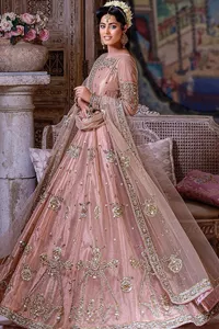 Wrap yourself in stunning style on your Big day. This tea-pink maxi dupatta is a stunning attire to wear at the wedding. This breathtaking nikah wear is gracefully adorned with hand-crafted embellishments and lavish golden work creating a magnificent masterpiece to give you your desired appearance. Intricate designs, floral details, naqshi, kora, Kundan, tilla and dabka o maxi enhance the overall charm of this beautiful outfit. The full sleeves of the maxi are highlighted with golden embroidery. Further, the boat shape neckline makes this outfit an epitome of beauty. It is systemized with a dupatta in the same colour adorned with four-sided borders and floral motifs all over.