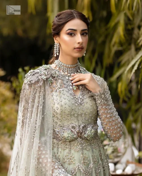 This enchanting ensemble features intricate silver and grey embroidery which involves tilla, dabka, kora, Kundan, and luxurious fabrics, making it