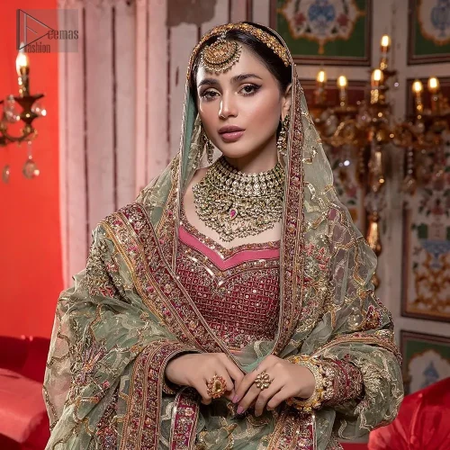 This breathtaking ensemble fuses perfection with vibrant elegance. The sweetheart neckline blouse, in a delicate shade of pink, features intricate