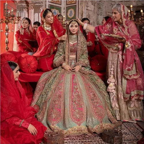 The flowing pistachio green lehenga, adorned with gotta work and applique, sways with every step,  while the net dupatta adorned