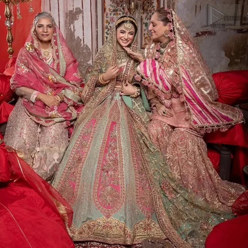 The net dupatta adorned with gotta and zardozi work creates a regal aura, perfect for your reception or first day.