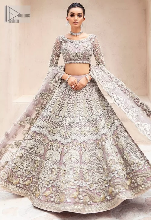 The chic short blouse, with its sophisticated boat neckline and sleeves, brings a modern touch, while the flowing lehenga embodies