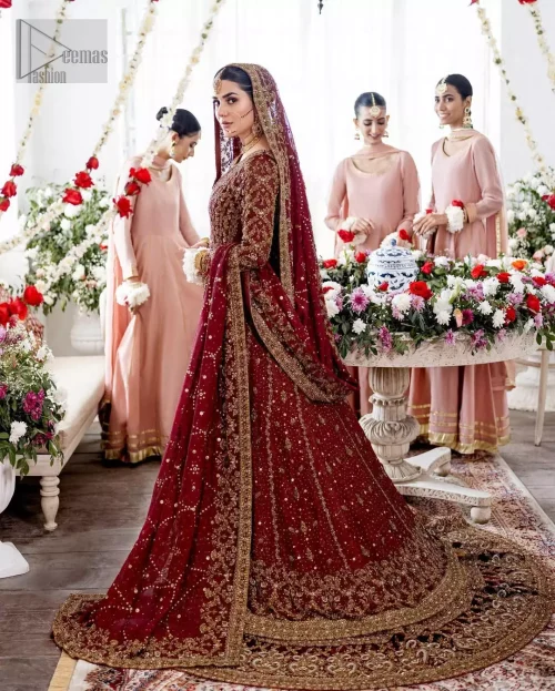 Golden embroidery radiates across the maroon front-open pishwas with detailed handwork.