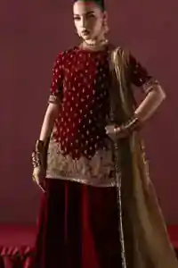 Model wearing maroon velvet outfit at an evening wedding party.